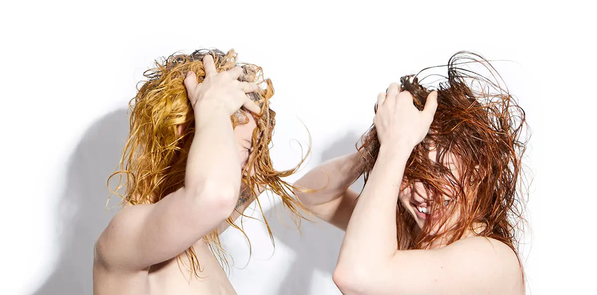 two people holding their hair